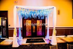 a decorated stage with white drapes and blue lights