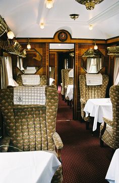 the inside of a train car with many tables and chairs in it's dining area