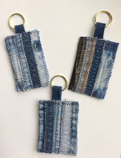 three pieces of denim with metal rings hanging from them