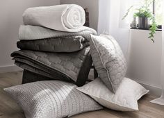 pillows and blankets stacked on top of each other