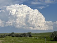 a large cloud looms over an open field