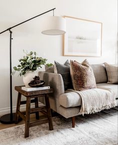 a living room filled with furniture and a large white rug on the floor next to a lamp