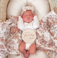 a baby is laying in a basket with a name tag