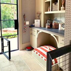 a kitchen with an open door leading to the outside area and storage cabinets on either side