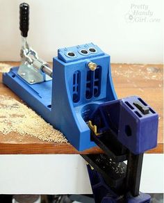 a drilling machine is being used to make holes in the wood on top of a workbench