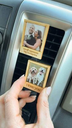 a person is holding two pictures in their car's air freshener dispenser