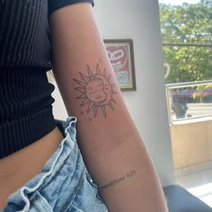 a woman with a sun tattoo on her arm