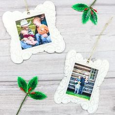 two christmas ornaments are hanging on a wooden table, one is decorated with holly leaves and the other has an ornament