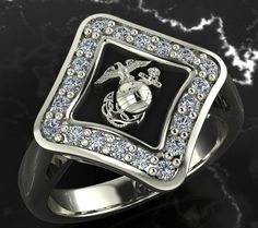 a ring with an eagle and globe on it, surrounded by crystal stones in front of a black marble background