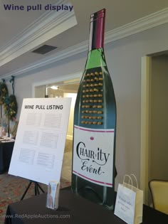 a wine bottle sitting on top of a table next to a sign