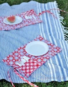 a picnic blanket with plates and utensils on it