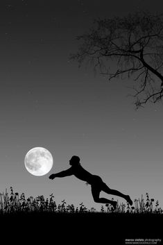 a person jumping up into the air in front of a full moon