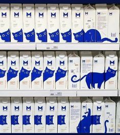 milk cartons with blue cats on them in a grocery store display case, one for milk and the other for milk