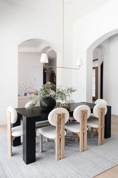 a dining room table with white chairs around it