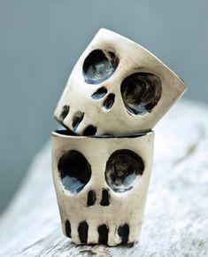 two silver skulls sitting on top of each other