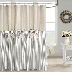 a white and black striped shower curtain next to a window