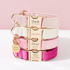 three pink and white bracelets with personalized tags on each one, two different colors