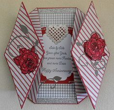 an origami card box with two roses in it and a heart on the inside