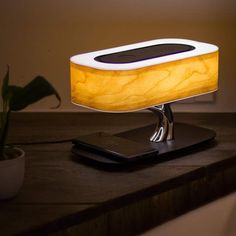 a table lamp that is on top of a tabletop next to a cell phone