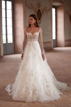 a woman in a white wedding dress with long sleeves