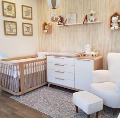 a baby's room with a crib, chair and dresser