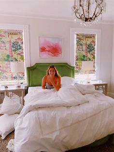 a woman laying on top of a bed in a bedroom