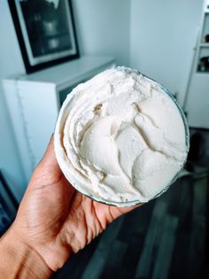 a person holding up a bowl of whipped cream