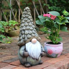 a gnome statue sitting next to a potted plant