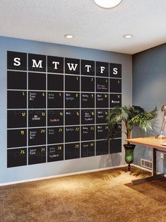 a room with a desk and a large calendar on the wall above it that says smtwifs