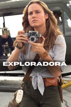 a woman holding a camera in front of a helicopter with the caption exploradora