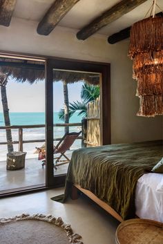 a bedroom with an ocean view is pictured in this image from the bed room looking out onto the beach