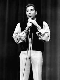 a man standing on top of a stage holding a microphone