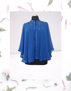 Feel like royalty in this stunning Royal blue chiffon evening cape/shawl.  This one-of-a-kind piece is hand embellished with artsy details, perfect for making a statement at any event. Each circle is meticulously hand embroidered with sequins and appliqued onto the cape with care.  The glitter ribbon frame trim adds an extra touch of elegance and sophistication to this beautiful evening cover up.  This L-XL cape is truly a work of art that will make you stand out in style. One of a kind  Fastene Elegant Spring Cape Shawl, Party Chiffon Shawl, One Size Blue Cape, Blue One Size Cape, Blue One-size Cape, Half Cape, Dress Topper, Formal Top, Cape Shawl