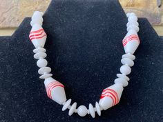 "This beautiful signed Japan necklace features art glass red and white oblong beads separated by smaller milk white beads. Shepherd's hook closure. Probably dates to the 1940s/50s but has an Art Deco design.  12\" choker length so very small size. The necklace can be adjusted to add another 2.5\" by placing the hook further along the beads. The Japan hallmark is on the hook (I needed a magnifying glass to see it).   In good vintage condition although the hook closure and other metalwork is discoloured. There is also a tiny mark on one of the separator beads.  Please note that all jewellery sold at Cheryl's Treasure Box is in vintage condition and I encourage you to look at the detailed photos. All stones/ metals are costume unless otherwise stated. Feel free to message me with any question Le Crochet, Detailed Photos, White Milk Glass, Beaded Choker Necklace, Magnifying Glass, Necklace Vintage, Featured Art, Art Deco Design, Beaded Choker