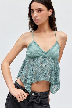 Swingy Kimchi Blue tank top in a cropped babydoll silhouette. Features a plunging v-neckline with spaghetti straps, triangle cups with lace trim and a flowy sheer lace bodice. Finished with a hanky hem for added movement. Exclusively at Urban Outfitters. Features Kimchi Blue Lilian lace hanky hem babydoll cami Empire waist tank top Soft & stretchy sheer lace Plunging v-neckline with spaghetti straps Triangle cups with lace trim Sheer lace bodice Hanky hemline Babydoll fit Cropped length Adjustab Low-cut Camisole With Built-in Bra For Spring, Summer Triangle Top Bra Friendly Camisole, Spring Low-cut Camisole With Built-in Bra, Summer Lace V-neck Crop Top, Summer V-neck Lace Crop Top, Summer Triangle Top Camisole, Bra Friendly, Low-cut Blue Summer Tops, Summer Bra-friendly Triangle Top Camisole, Blue Lace Cami Top