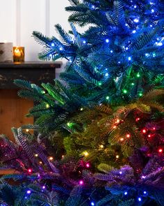 a blue christmas tree with multi - colored lights