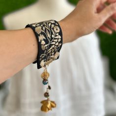 a close up of a person's arm wearing a bracelet with flowers on it