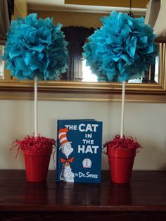 the cat in the hat book and two red flower pots with blue pom - poms