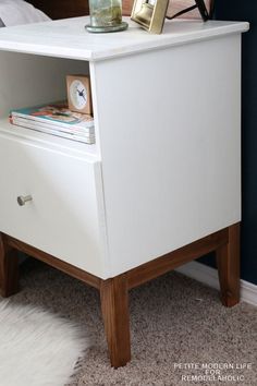 a white nightstand with a clock on top