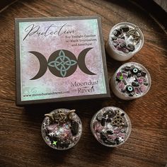 an assortment of moondust jewelry sitting on top of a wooden table next to a box