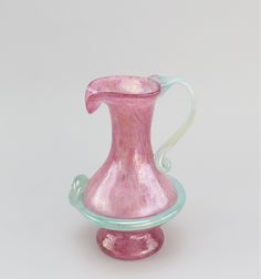 a pink glass vase sitting on top of a table