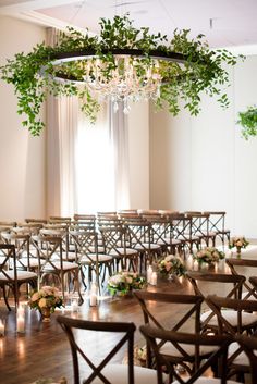 a room filled with lots of tables and chairs covered in greenery