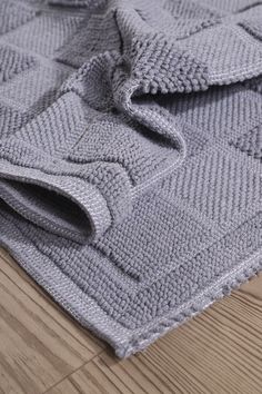 a gray sweater laying on top of a wooden floor