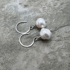 "Lustery 8mm, round saturn freshwater pearls wrapped in oxidized sterling silver. These beauts hang 1/2\" from the bottom of hand hammered and oxidized sterling silver earwires.  A classic!" Nickel-free Sterling Silver Pearl Earrings For Everyday, Nickel-free Silver Sterling Pearl Earrings, Pear-shaped Sterling Silver Pearl Charm Earrings, Hallmarked Sterling Silver Dangle Pearl Earrings, Handmade Silver Shell-shaped Pearl Earrings, Oxidized Sterling Silver, Fresh Water, Sterling Silver Earrings, Freshwater Pearls