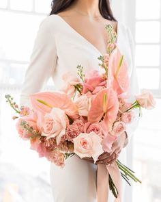 a woman holding a bouquet of pink flowers