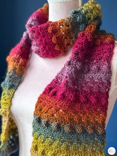 a multicolored crocheted scarf on a mannequin