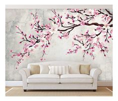 a living room with a white couch and pink flowers painted on the wall behind it