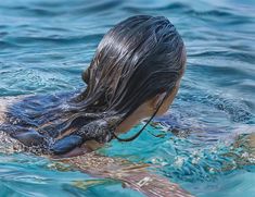 a woman with wet hair swimming in the ocean