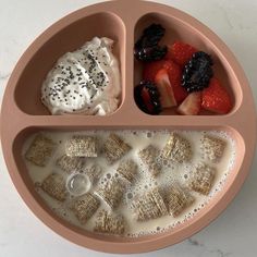 a pink plate topped with fruit and crackers on top of a white countertop