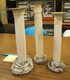 two tall white pillars sitting on top of a wooden table